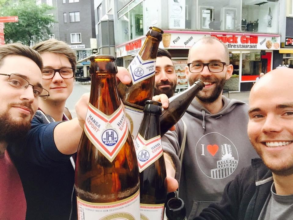 Eine Gruppe hebt Bierflaschen in die Kamera